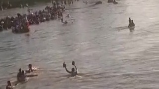 Haitianos huyen de la violencia cruzando un río a nado